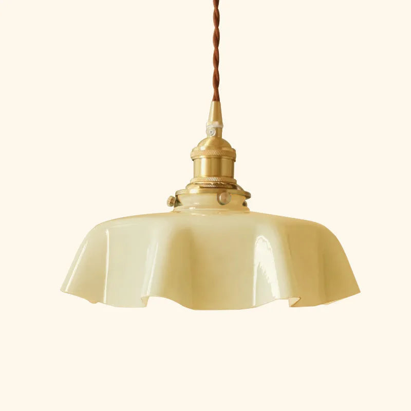 Medieval-style brass flower bud chandelier with a cream glass shade hanging from an adjustable cord.