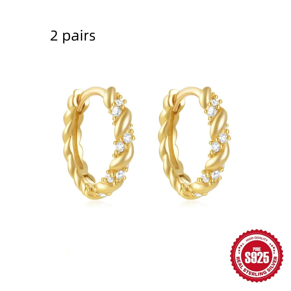 Sterling silver geometric stud earrings with a small round shape and classic diamond detail on a white background.