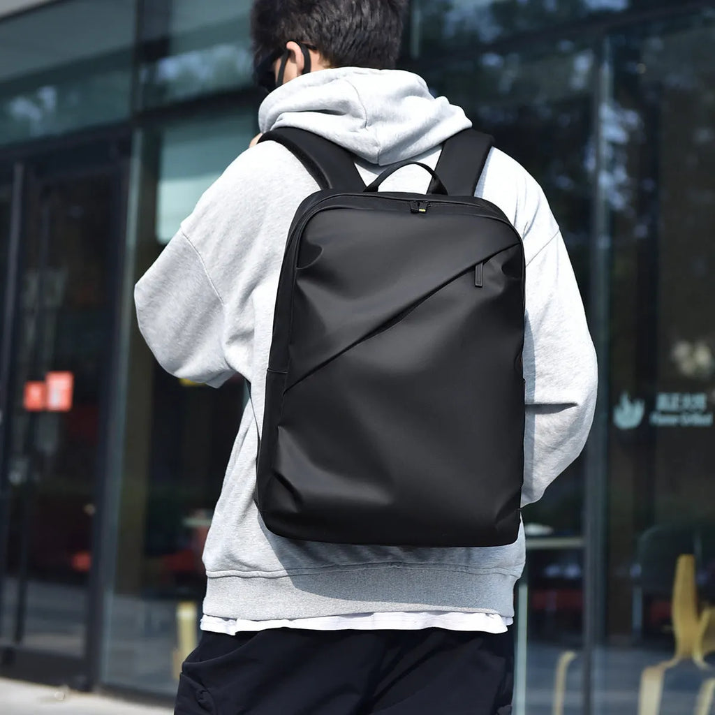 Waterproof laptop backpack in black showing large main compartment and simple design with sewing thread detailing