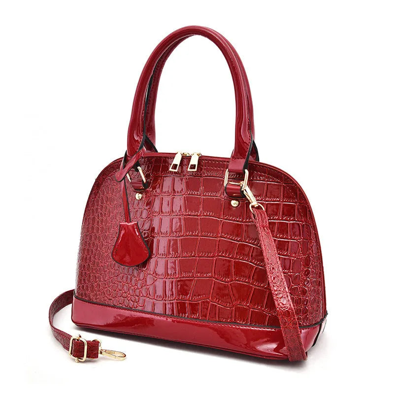 Shiny PU crossbody shoulder bag in shell shape showing black, red, and brown colour options