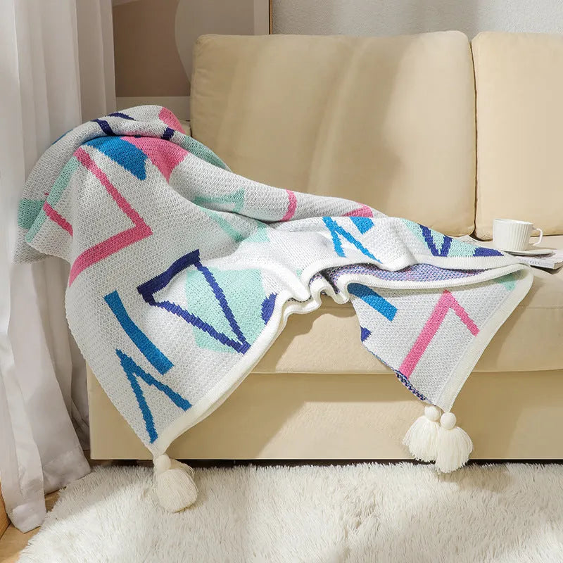 Bohemian-style acrylic sofa blanket with tassel edges in geometric pattern or solid colour options