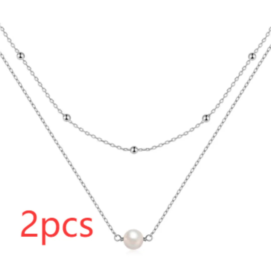 S925 sterling silver double layer necklace with twin pearls in gold or white gold finish featuring geometric pendant and ball bead chain.