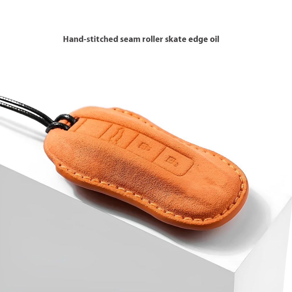 Suede car key cover for Porsche-style fobs in cement grey, dark green, light grey, and orange colour options