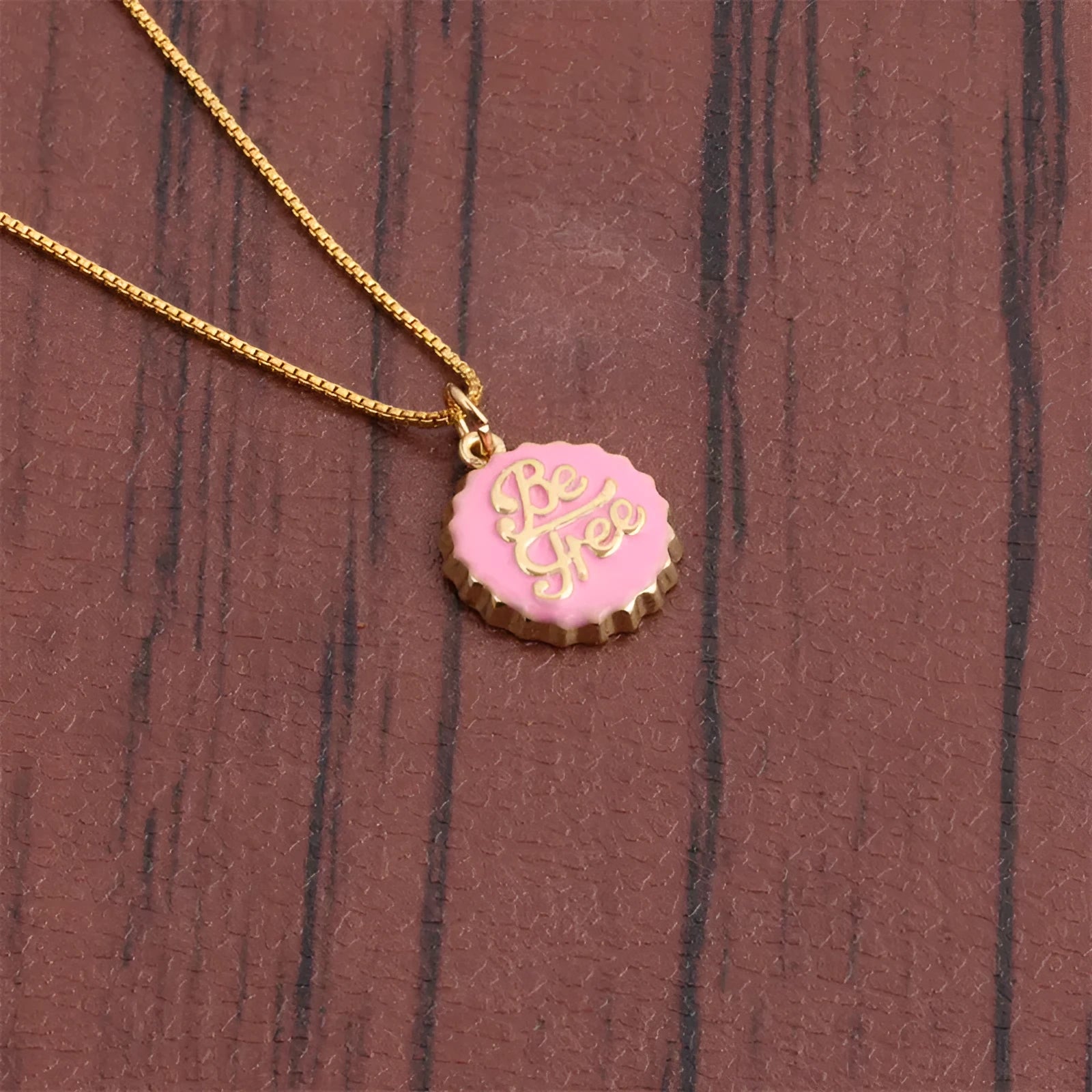 Copper bottle cap pendant necklace with gold electroplating on a box chain, shown in multiple colour options.
