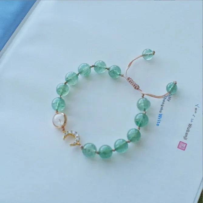 Handcrafted strawberry quartz crystal bracelet with peach blossom design on wrist