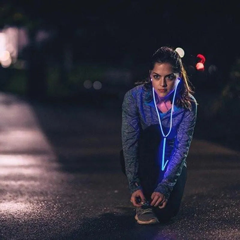 Blue LED light up earphones with 3.5mm plug and in-line remote control on a dark background
