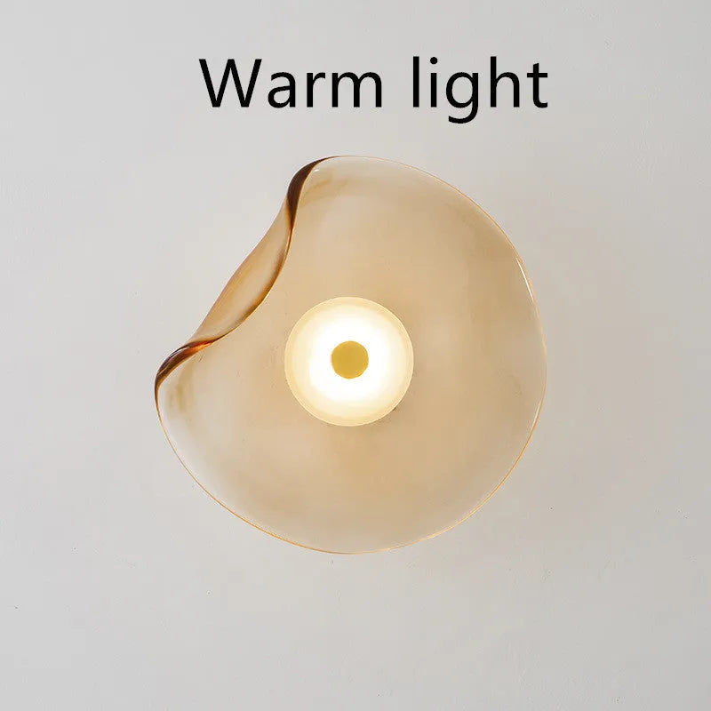 Round glass wall lamp for bedroom bedside in cognac, grey or light colour finishes.