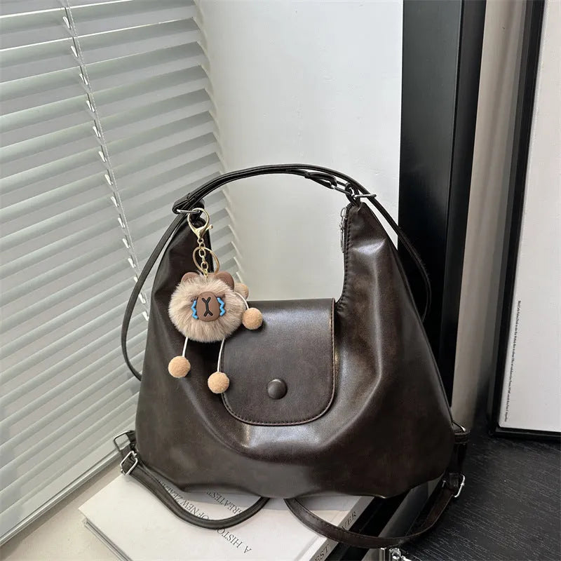 Women's textured PU leather shoulder bag with single strap and mobile phone compartment in black colour