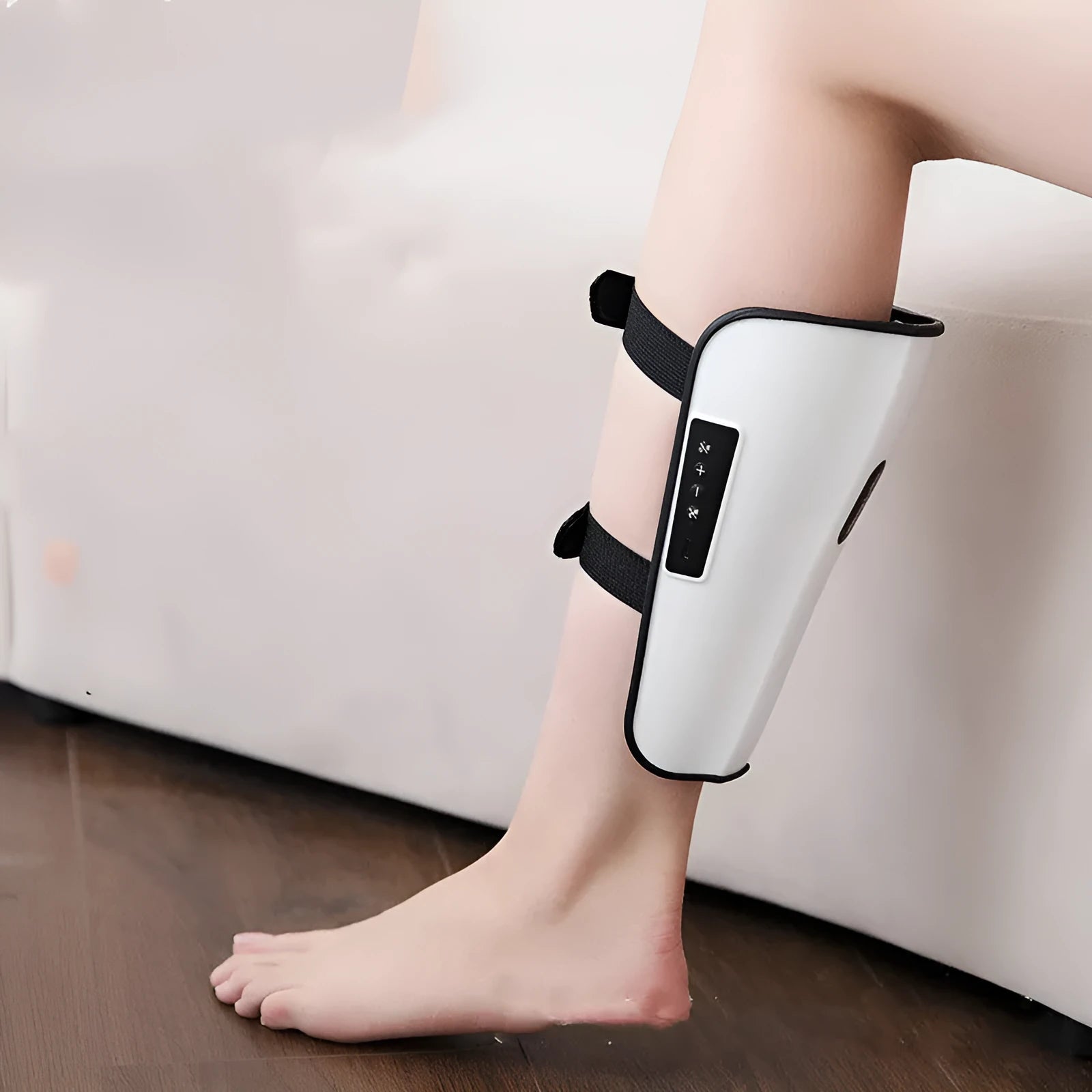 White portable electronic calf massager with control buttons, featuring infrared and electrotherapy functions.