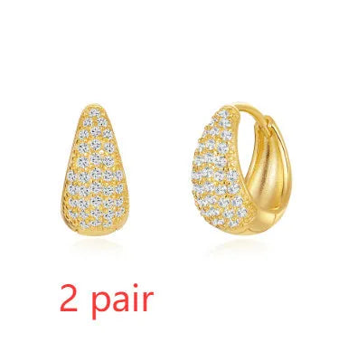 A pair of simple geometric brass earclip earrings with a round element and electroplated golden finish.