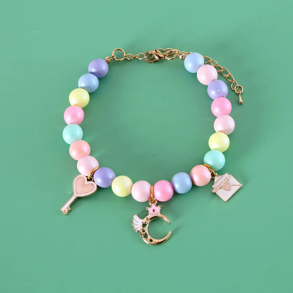 Macaron-coloured resin pet collar and bracelet set for birthday photoshoots on a neutral background.