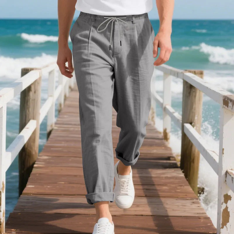 Men's loose-fit straight-leg linen trousers in light khaki colour with a drawstring waist.