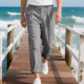 Men's loose-fit straight-leg linen trousers in light khaki colour with a drawstring waist.