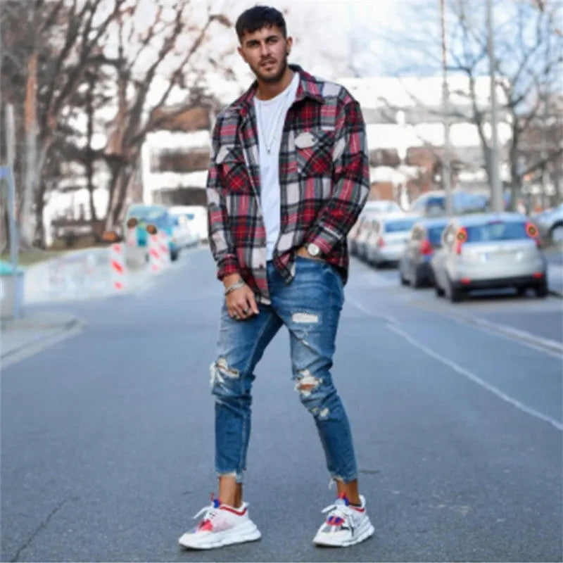 Men's deep blue cotton jeans featuring distressed hole details on the legs.