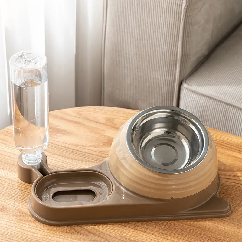 Brown elevated cat bowl with attached water dispenser bottle on a wooden floor.