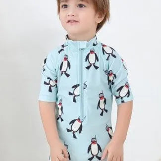 Boys' penguin print long sleeve swim top and matching swimming cap set on a hanger.