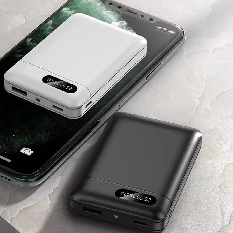 White or black large capacity portable power bank with multiple USB ports, shown next to a smartphone.