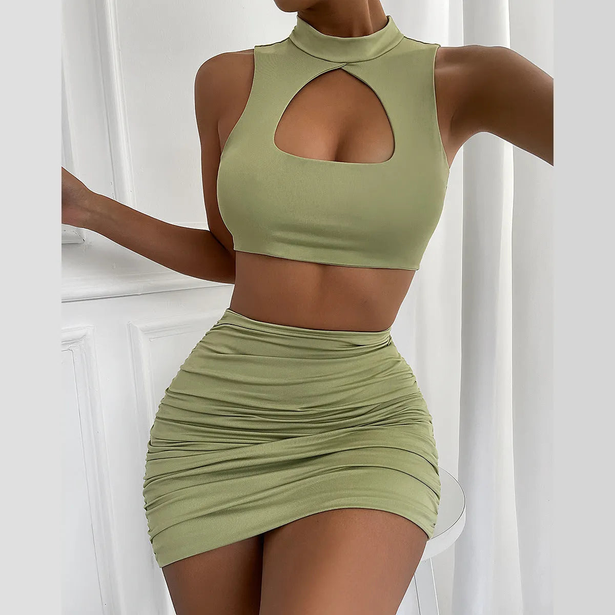 Light purple women's two-piece set with hollow-out vest and split skirt on a model.