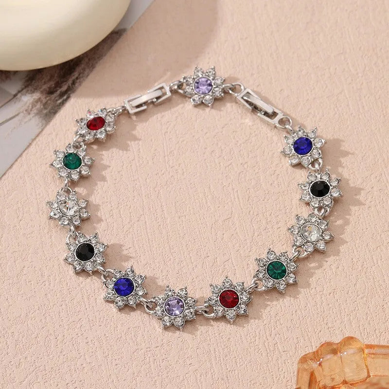 A gold or silver electroplated zinc alloy flower bracelet with coloured gems.