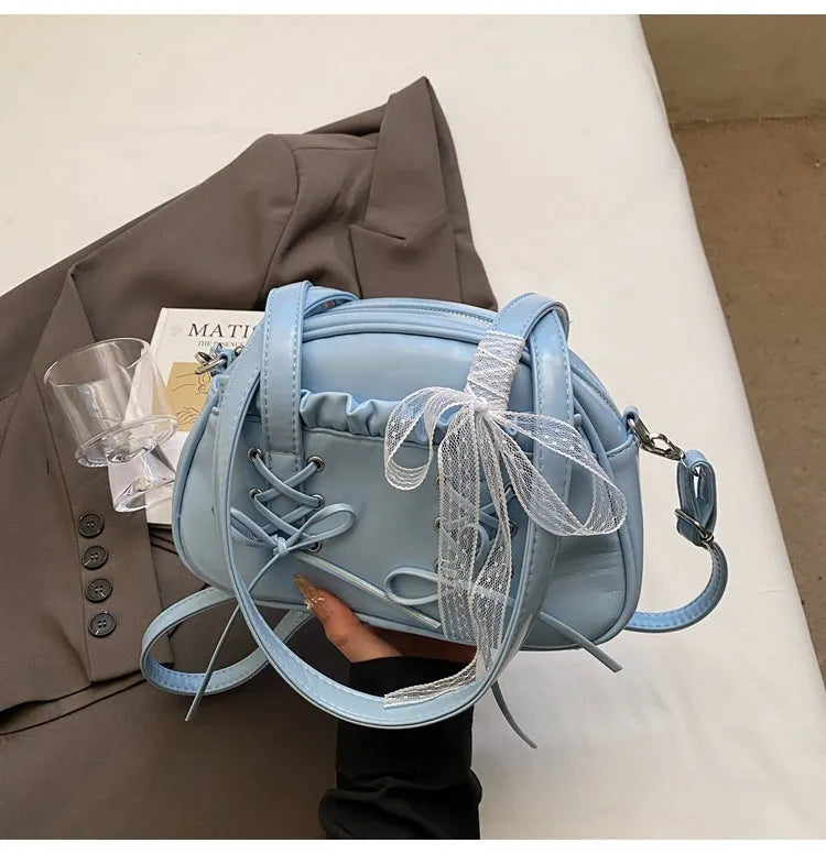 Milky white women's PU shoulder bag with a black bandage bow and sewing thread detail.