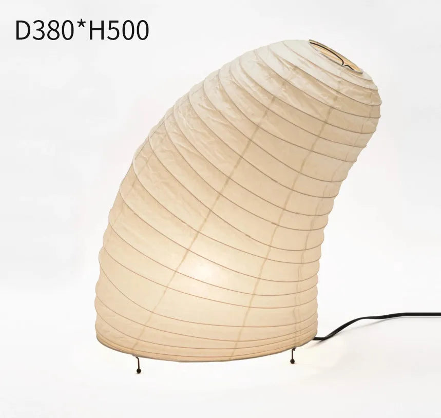 Japanese style handmade rice paper lantern table lamp with aluminium base on a wooden table.