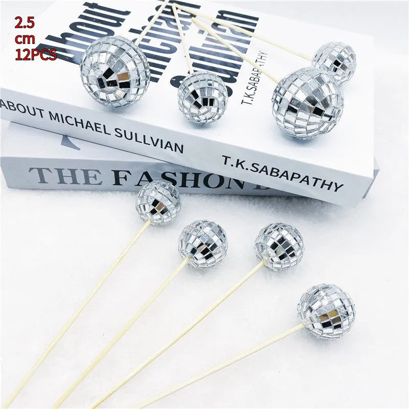 Silver reflective glass disco ball cake topper on a wooden stick for birthday party decoration.