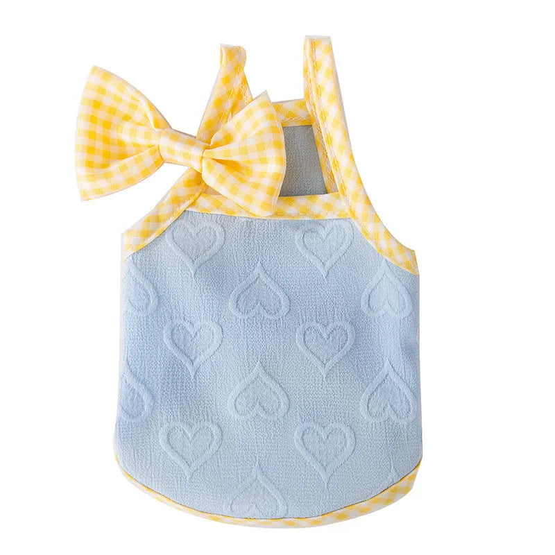 Small dog wearing heart pattern vest with bow suspenders in blue colour, showing elastic fit and decorative design