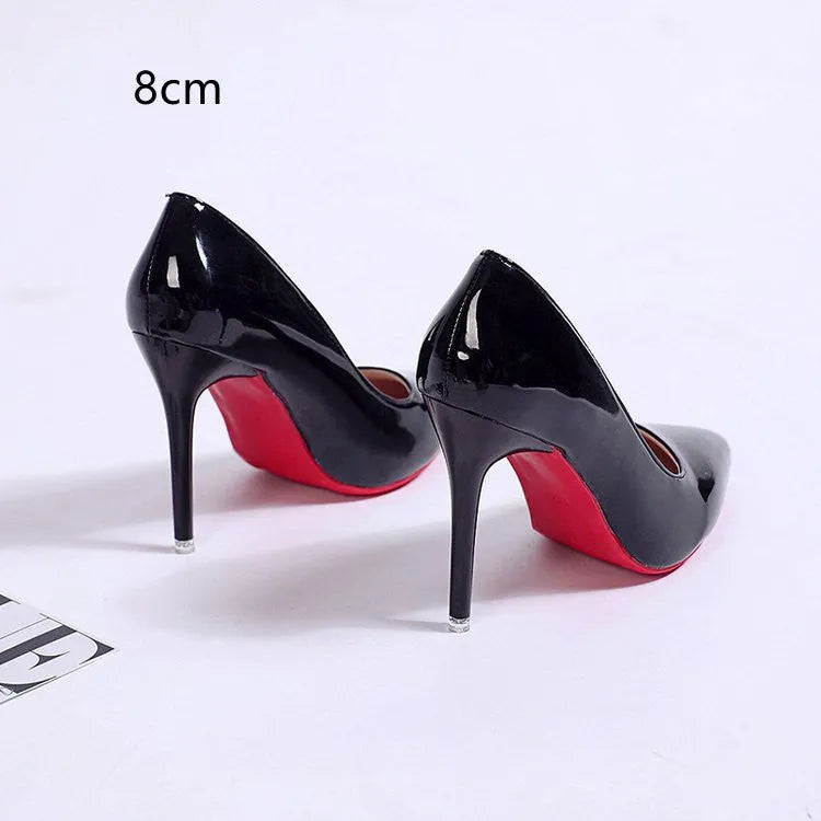Women's black pointed toe stiletto heel pumps with a shallow mouth design on a plain background.