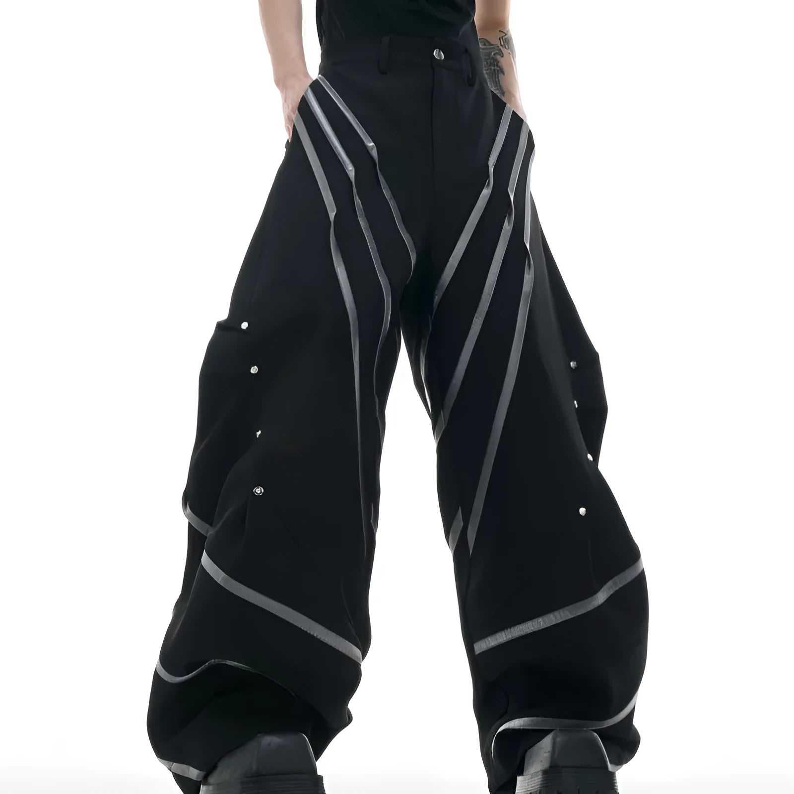 Men's black polyester trousers with front pleats and metal striped rivet details.