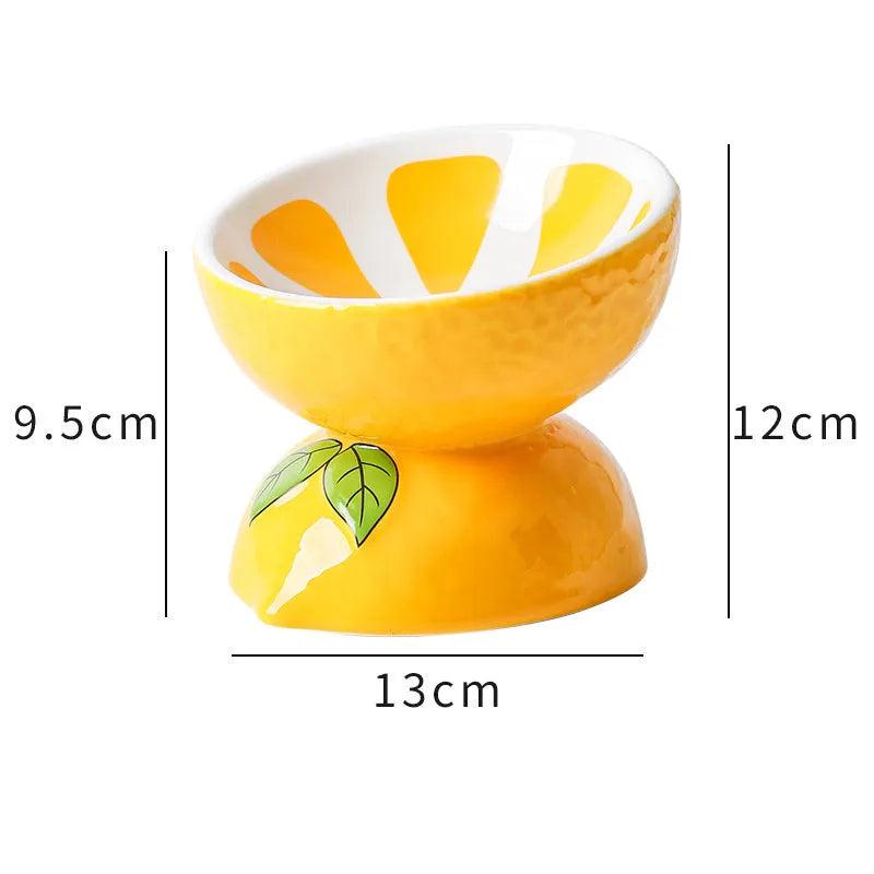 Ceramic elevated cat bowl with tilted surface in a colourful fruit pattern, showing its height and wide design.