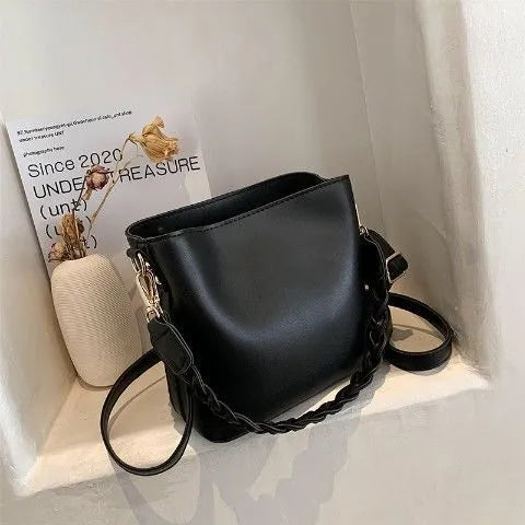 Khaki PU leather crossbody bucket bag with weaving texture and single shoulder strap.