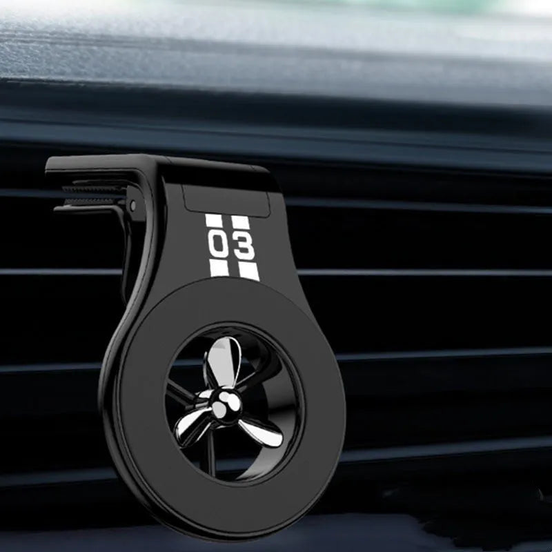 Magnetic car air vent phone holder with perfume dispenser in black, showing phone attached and fragrance slot.