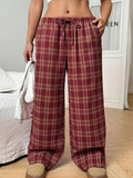 Red women's loose fit plaid trousers with drawstring waist and pockets on a mannequin.