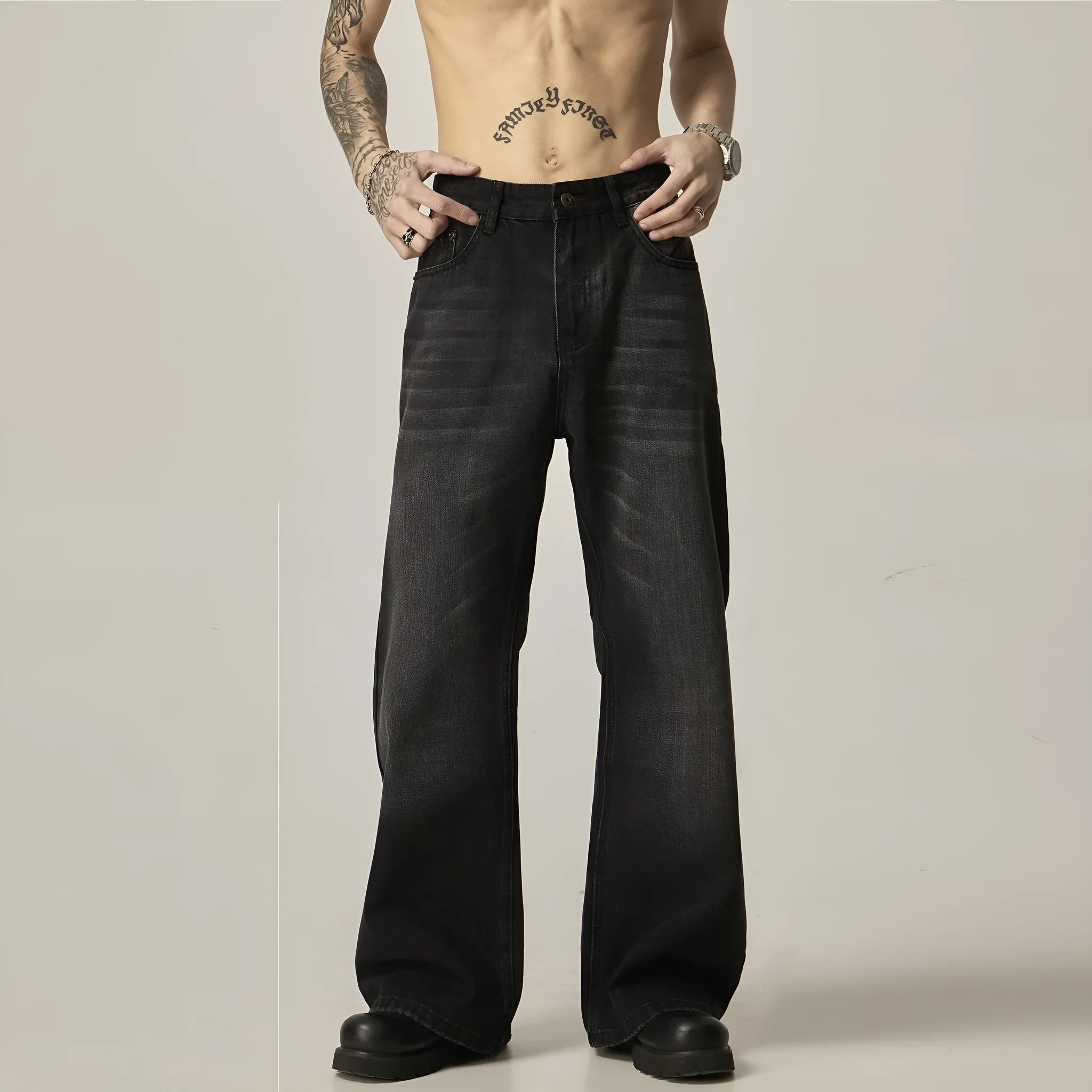 Man wearing black loose-fit straight-leg retro jeans in a casual setting.