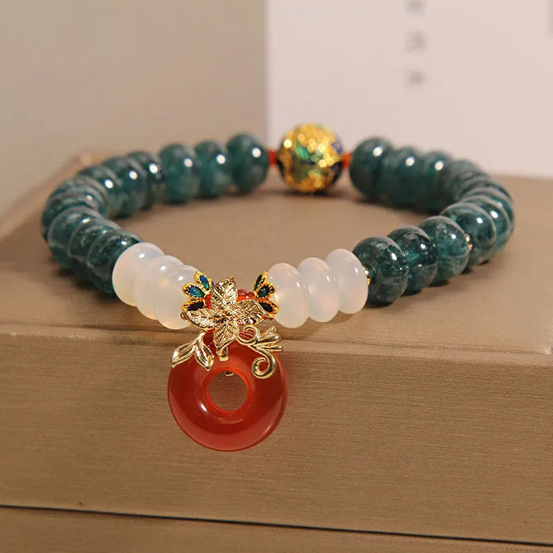 Blue water jade bead bracelet with red agate peace buckle closure and rhinestone details