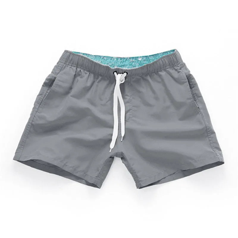 Men's polyester beach shorts with straight leg opening in multiple colours including black, white, and fluorescent yellow