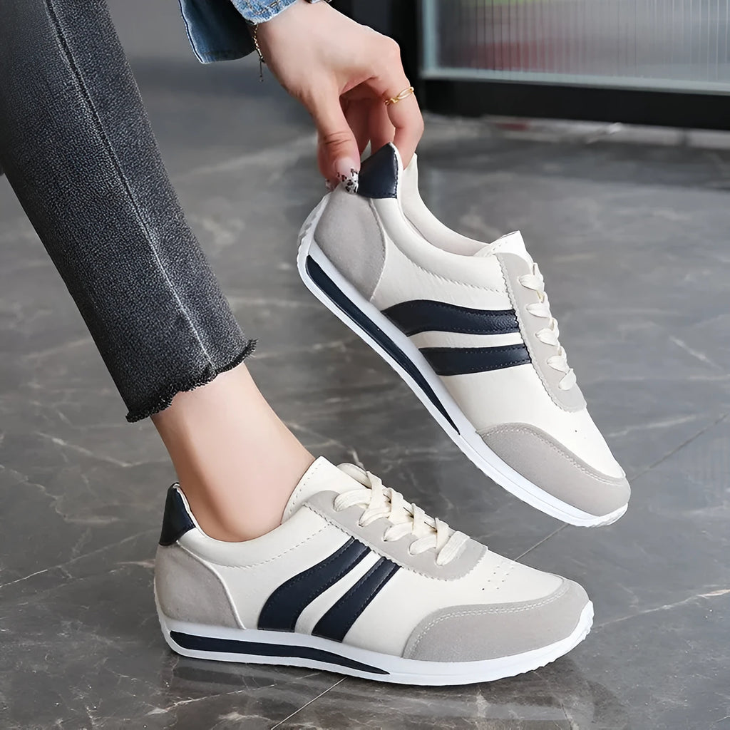 A pair of blue low-top lace-up running sneakers with a round toe and soft rubber sole on a white background.