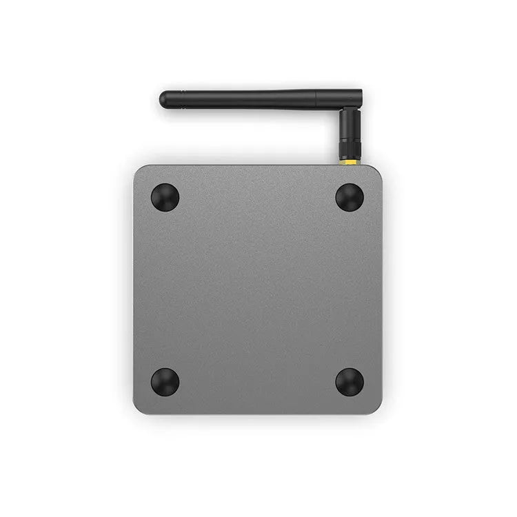 Android smart TV set-top box with voice remote control, HDMI cable, and power adapter on a table.