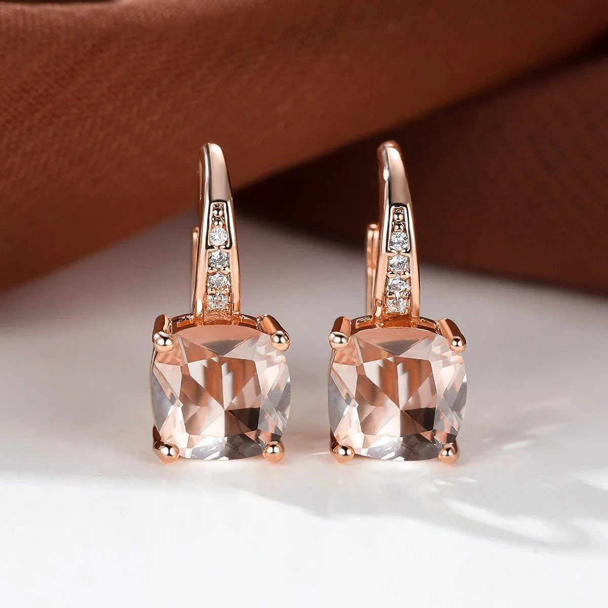 Square geometric ear hook earrings with zircon stones in an electroplated copper setting.