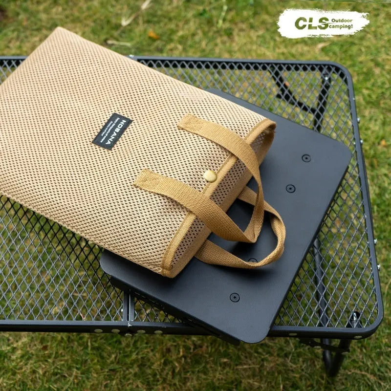 Aluminium folding camping stool that converts into a small table, shown with a tactical storage bag and a beige PU cushion.