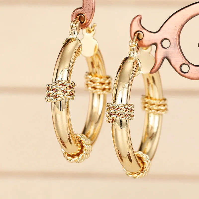Geometric copper earrings with gold tone finish showing ring and line design elements