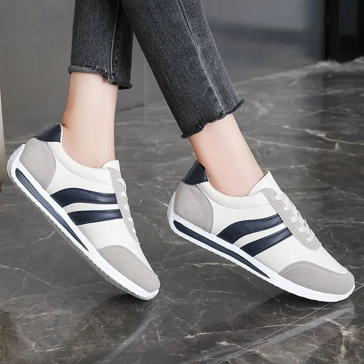 A pair of blue low-top lace-up running sneakers with a round toe and soft rubber sole on a white background.