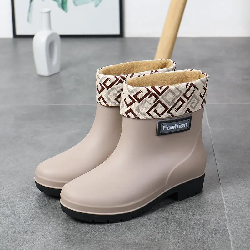 Women's mid-calf PVC rain boot in black on a wet surface.