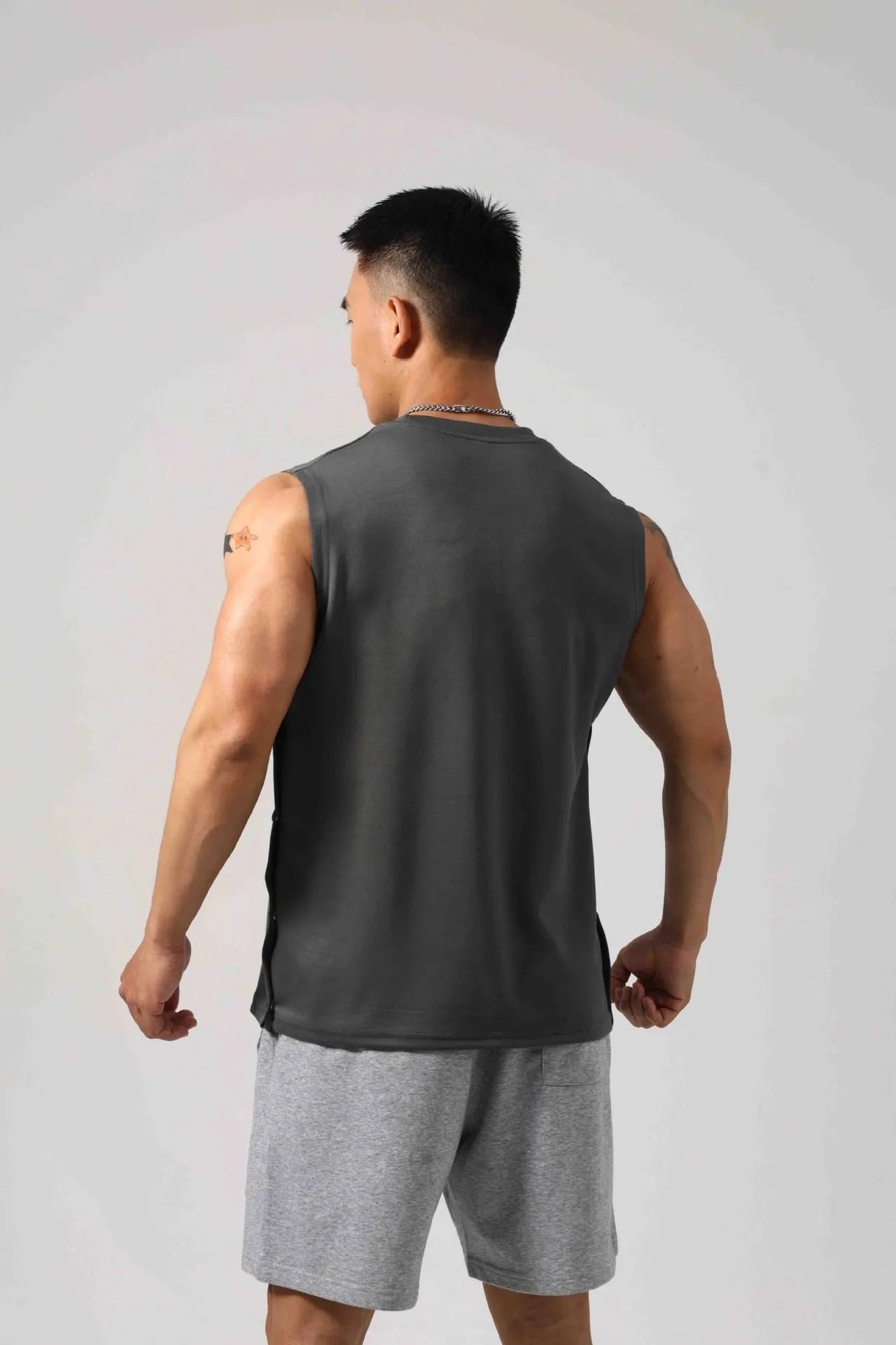 Men's black Korean style loose cotton fitness vest showing side hidden hook closure.