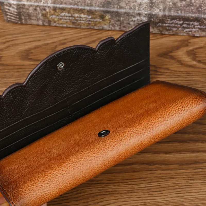 Women's brown genuine leather tri-fold wallet with embossed floral pattern showing open compartments