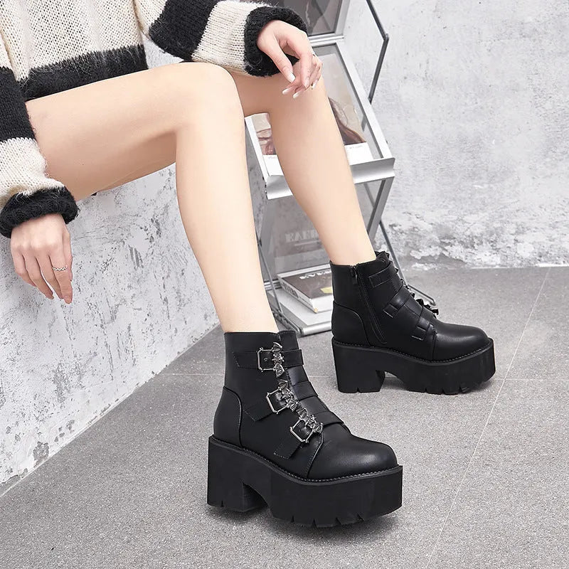 Black women's punk style ankle boots with bat buckle and side zip.