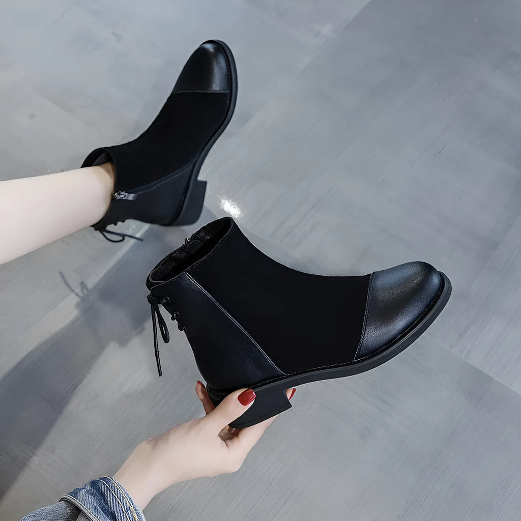 Black women's knee-high Martin boots with a bow detail and side zip on a rubber sole.