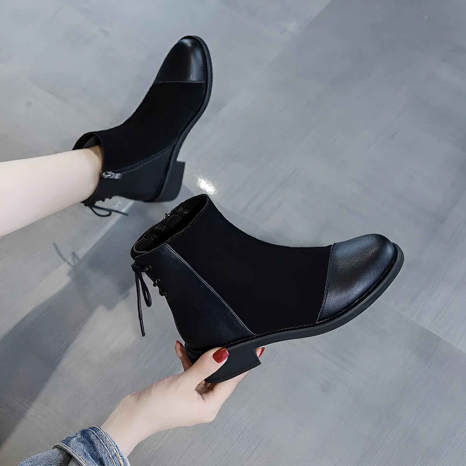 Black women's knee-high Martin boots with a bow detail and side zip on a rubber sole.
