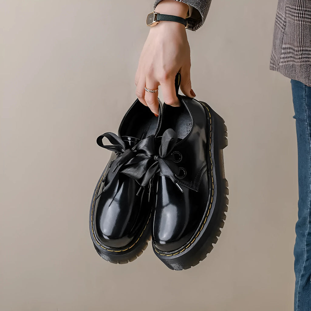 Women's black and white thick-soled leather shoes with lace-up closure and decorative straps