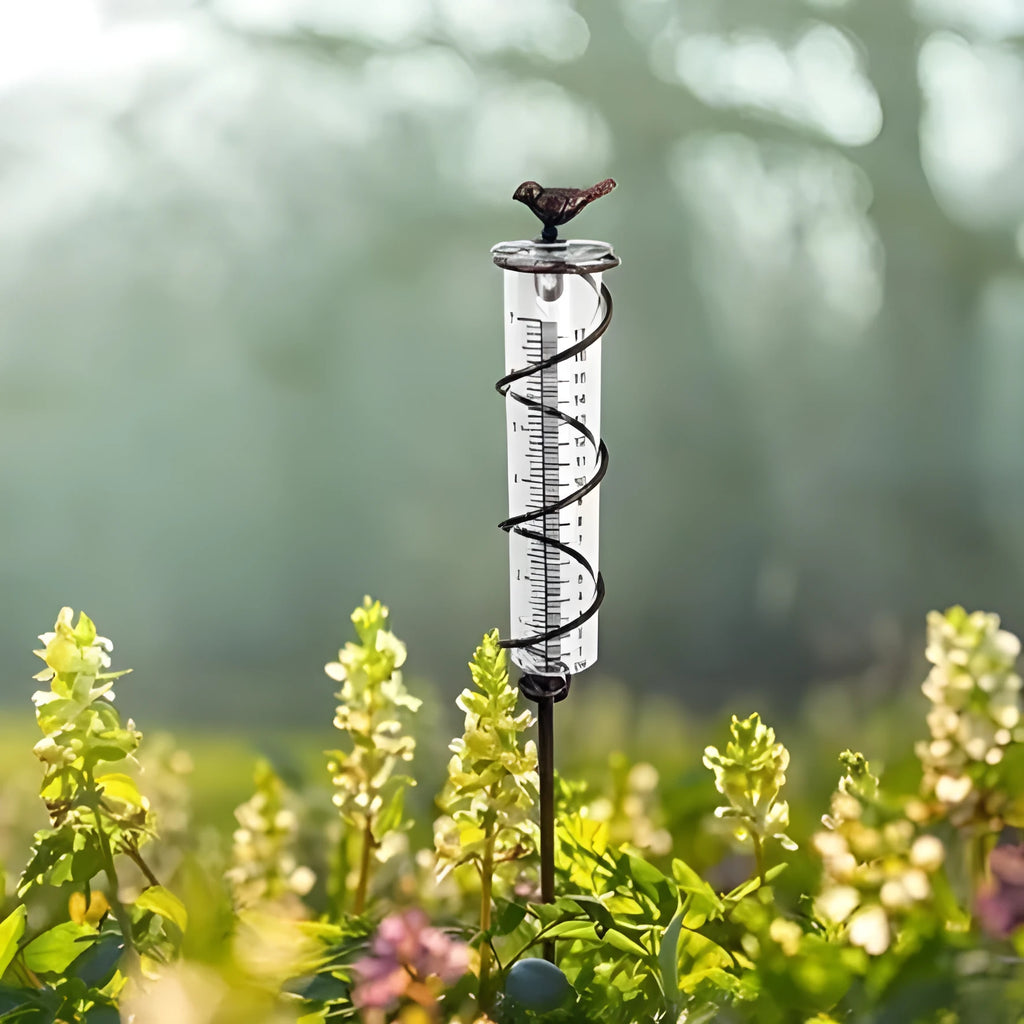 Cast iron garden hyetometer with glass rain gauge showing hummingbird design and measurement scale